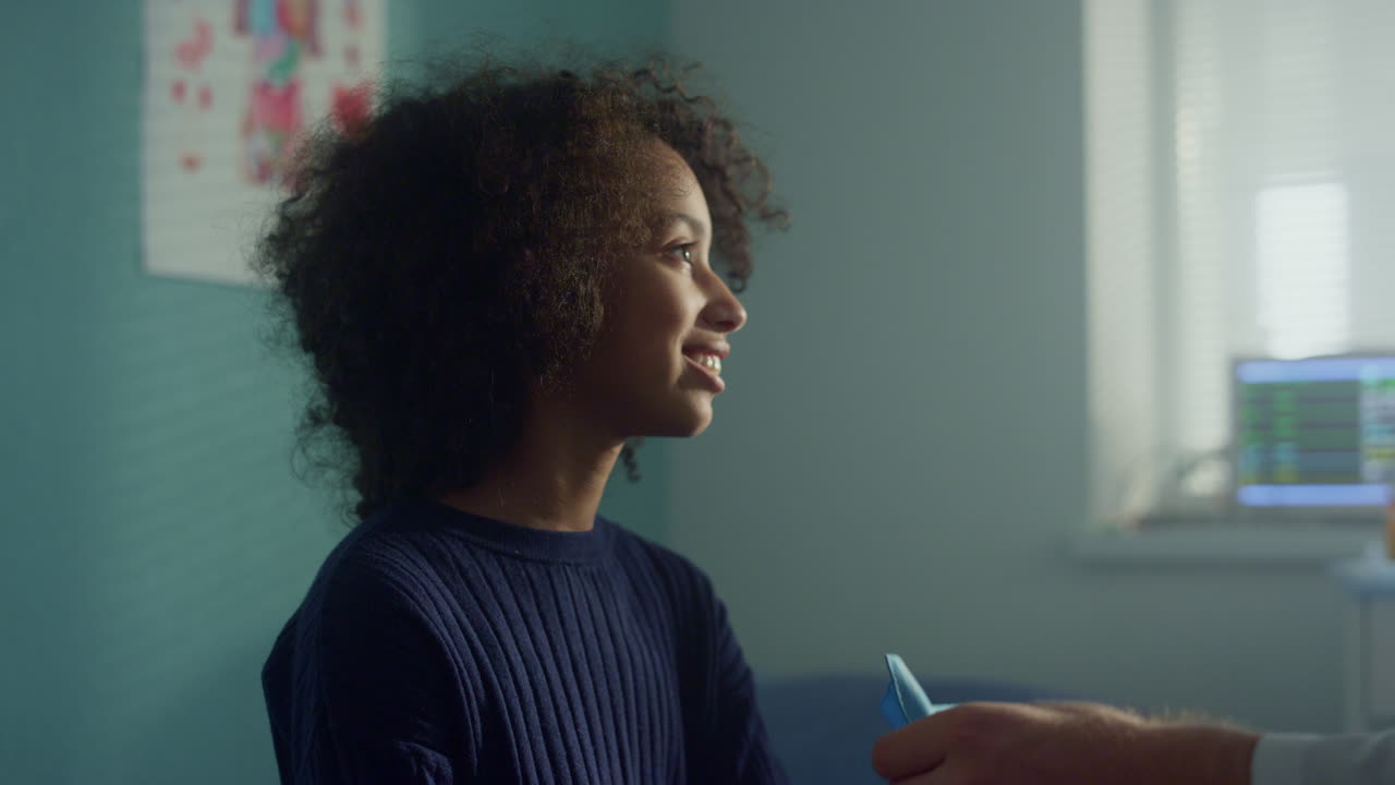 Smiling girl sitting clinic on consultation close up. Doctor using tonometer.