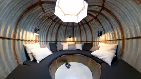 inviting and cozy circular seating nook with soft cushions and ambient lighting in a unique metal structure for relaxation and socializing
