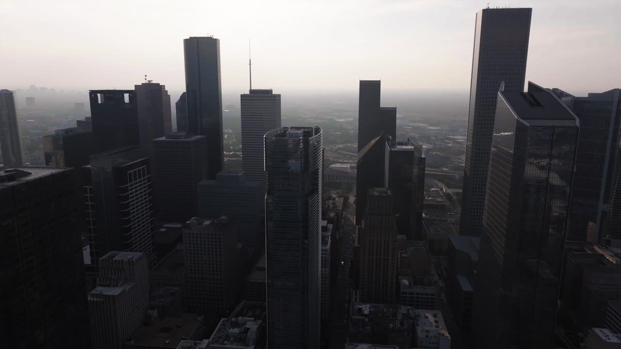 Volando entre edificios en el centro de Houston, un día brumoso en Texas, EE. UU. - Vista aérea.