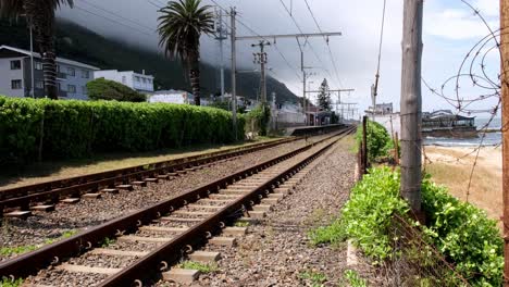 mist rolling down echo valley mountain slope towards kalk bay railway track, cape town