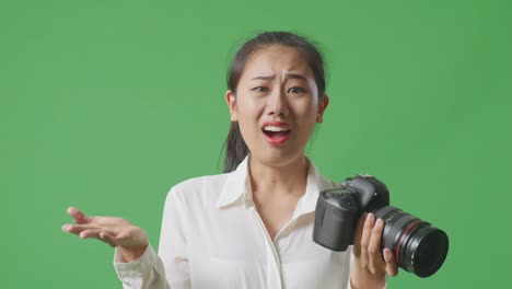 여성이 카메라를 들고 혼란스러워 보입니다.