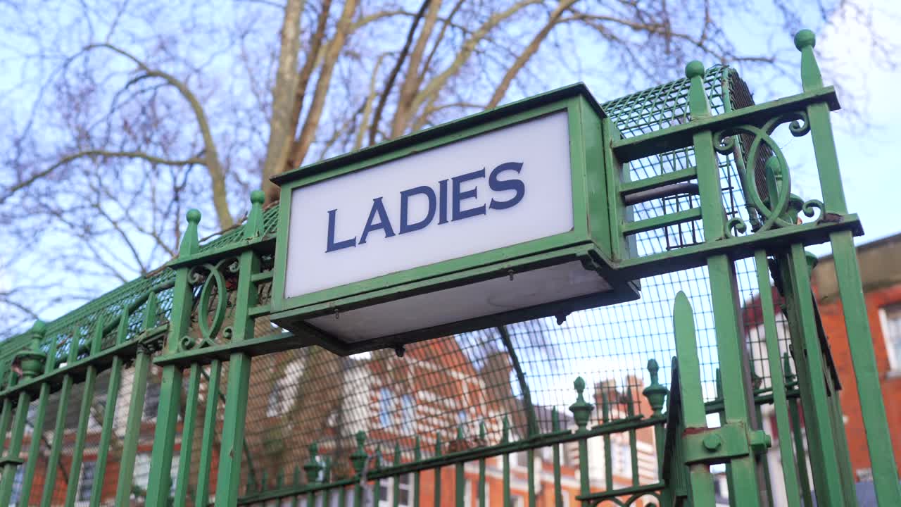 un letrero vintage de "damas" en un viejo baño público al aire libre bajo cielos soleados, diseño nostálgico y baños anticuados
