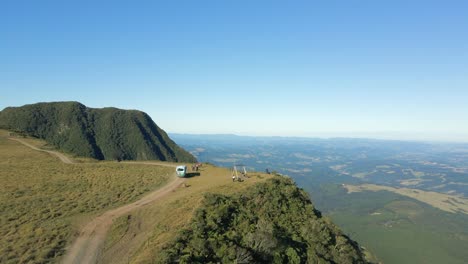 Bus-picking-up-tourists,-people-swinging-and-admiring-landscape-near-cliff