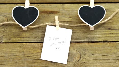 black hearts and envelope with i love u mom card hanging on rope