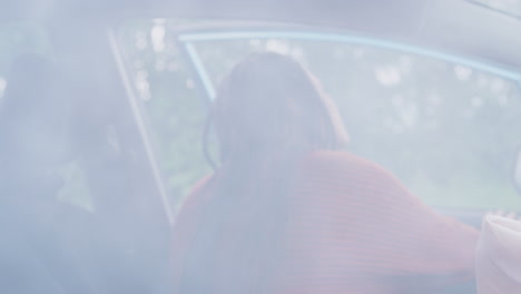 pasajera femenina saliendo del coche después de un accidente sufriendo una lesión en la cabeza