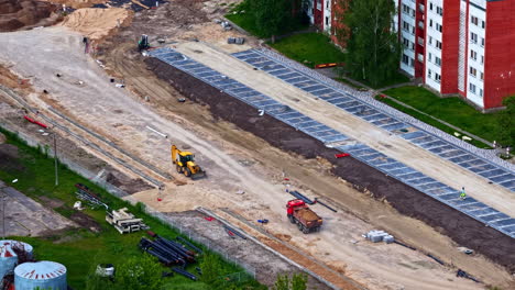 road construction project near residential buildings with machinery and groundwork