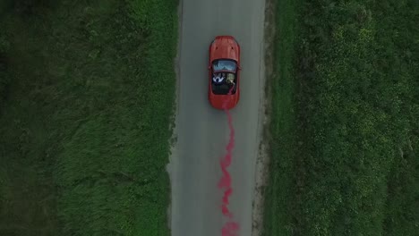 red convertible car driving on country road