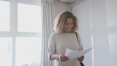mujer compradora por primera vez mirando la casa encuesta en la habitación para ser renovada