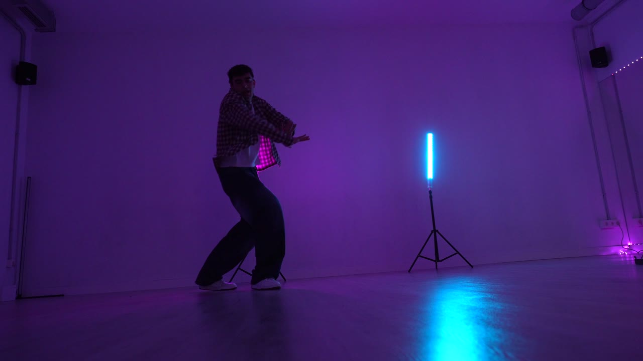 Man dancing in a studio with neon lights
