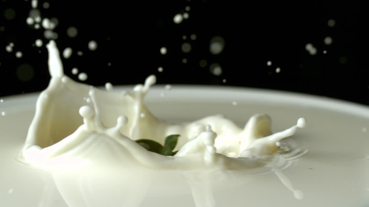 клубника падает в стакан молока