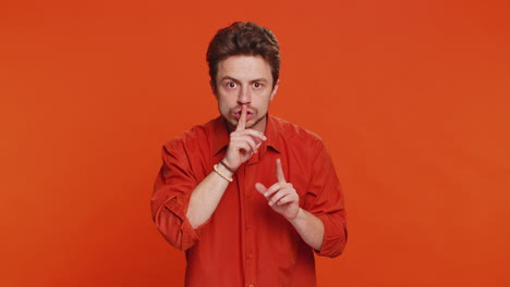 jonge man drukt vinger op lippen maak stilte gebaar teken vertel geen geheim stop roddelen privacy