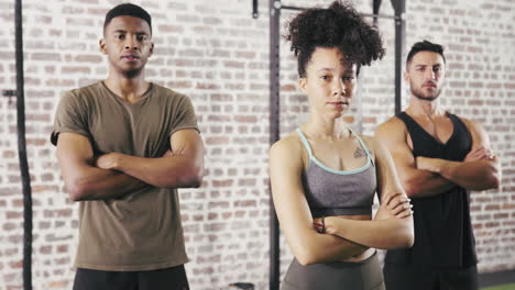 three people standing with their arms crossed