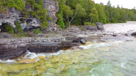 flying over the clear waters of lake huron to the pristine, vegetation covered shore