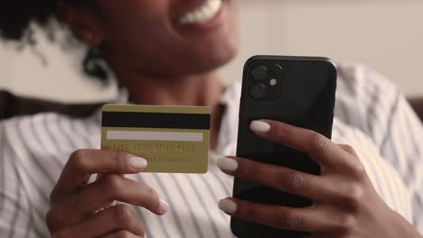 closeup hands of african female holding smartphone and card data