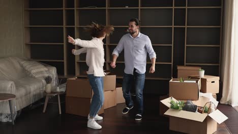 lively married couple celebrate relocation day dance in living room