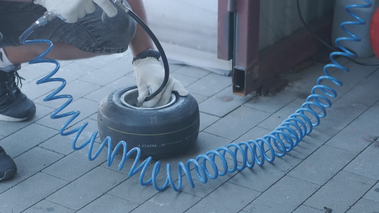 el mecánico del servicio de carreras de go kart cambia las ruedas