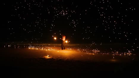 performer displays fire skills on the beach