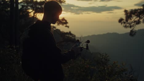 young person recording video at sunset in mountains