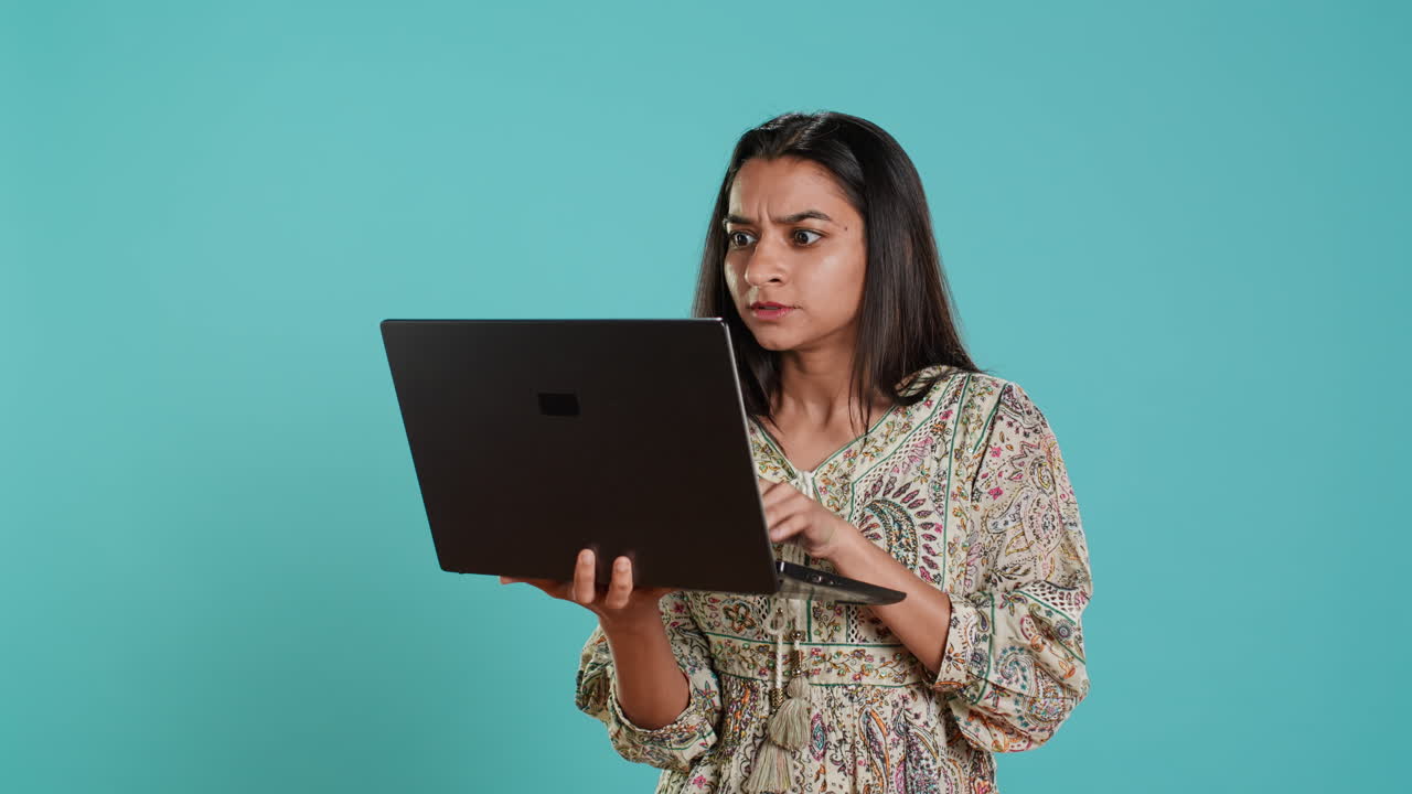 mujer escribiendo en el teclado de la computadora portátil y maldiciendo, sintiéndose enojada en el trabajo