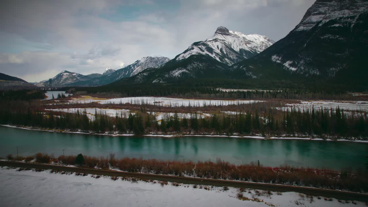A slow pan revealing the natural beauty of this teal river with mountains in the background. Located in Banff, Alberta, Canada.