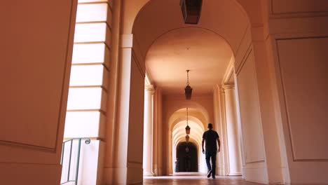 low static shot, of man walking into frame in hallway, at city hall in pasadena, california