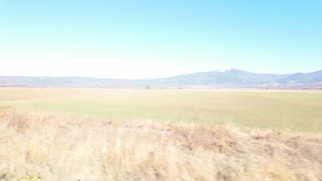 autumn footage of green farm fields in bulgaria with the balkan mountains in the background