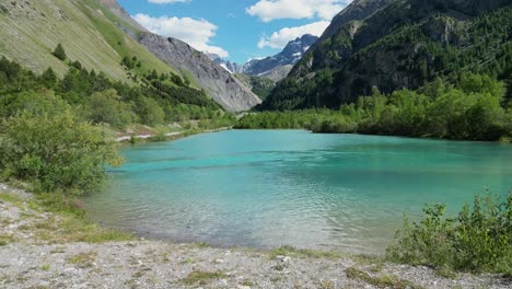turquoise light blue glacial lake in la grave - la meije, french alps, aerial dolly forward