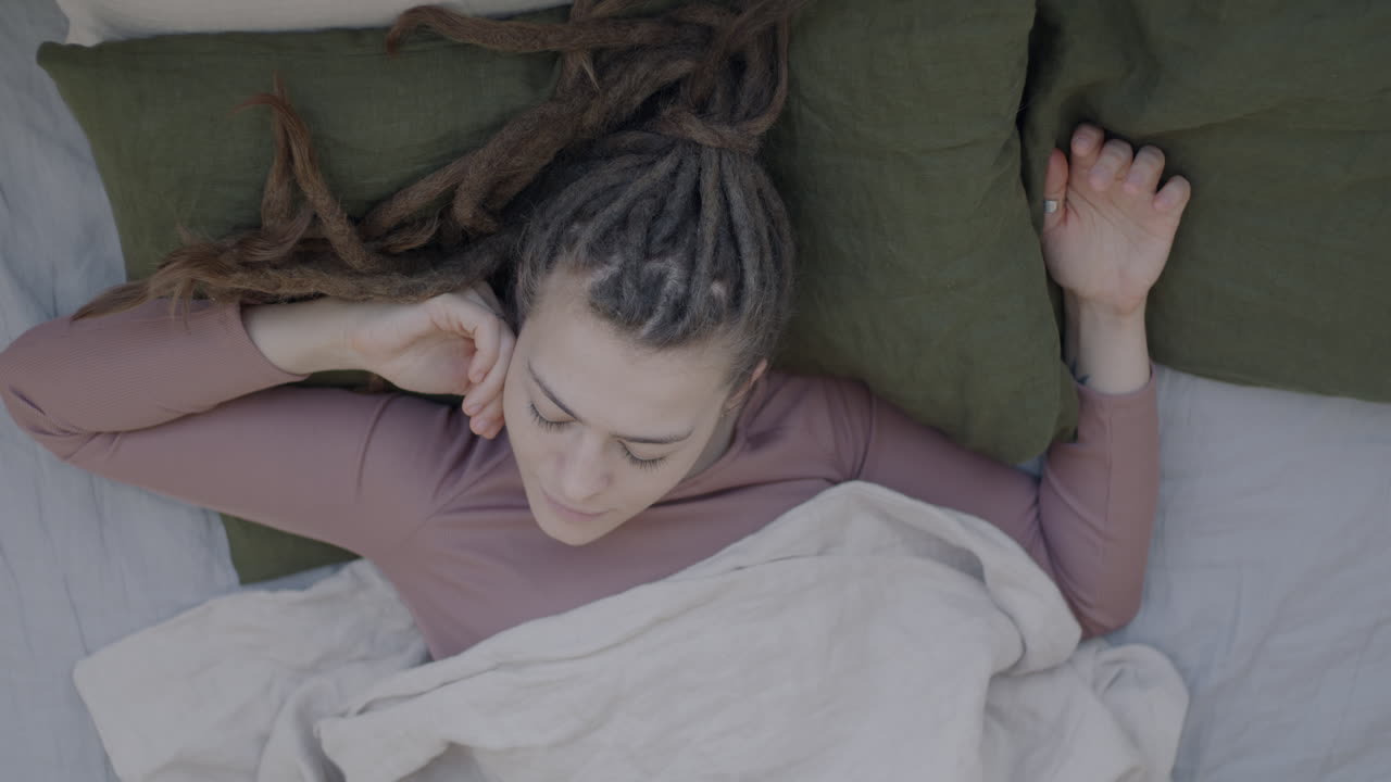 Woman Sleeping in Bed with Dreadlocks