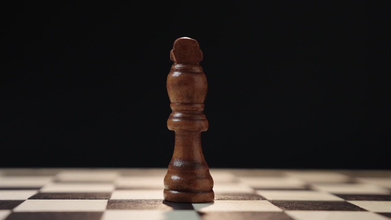 Pezzo degli scacchi del re solitario sulla scacchiera con movimento circolare cinematografico della telecamera che rappresenta leadership, autorità, strategia, potere e concetto di processo decisionale