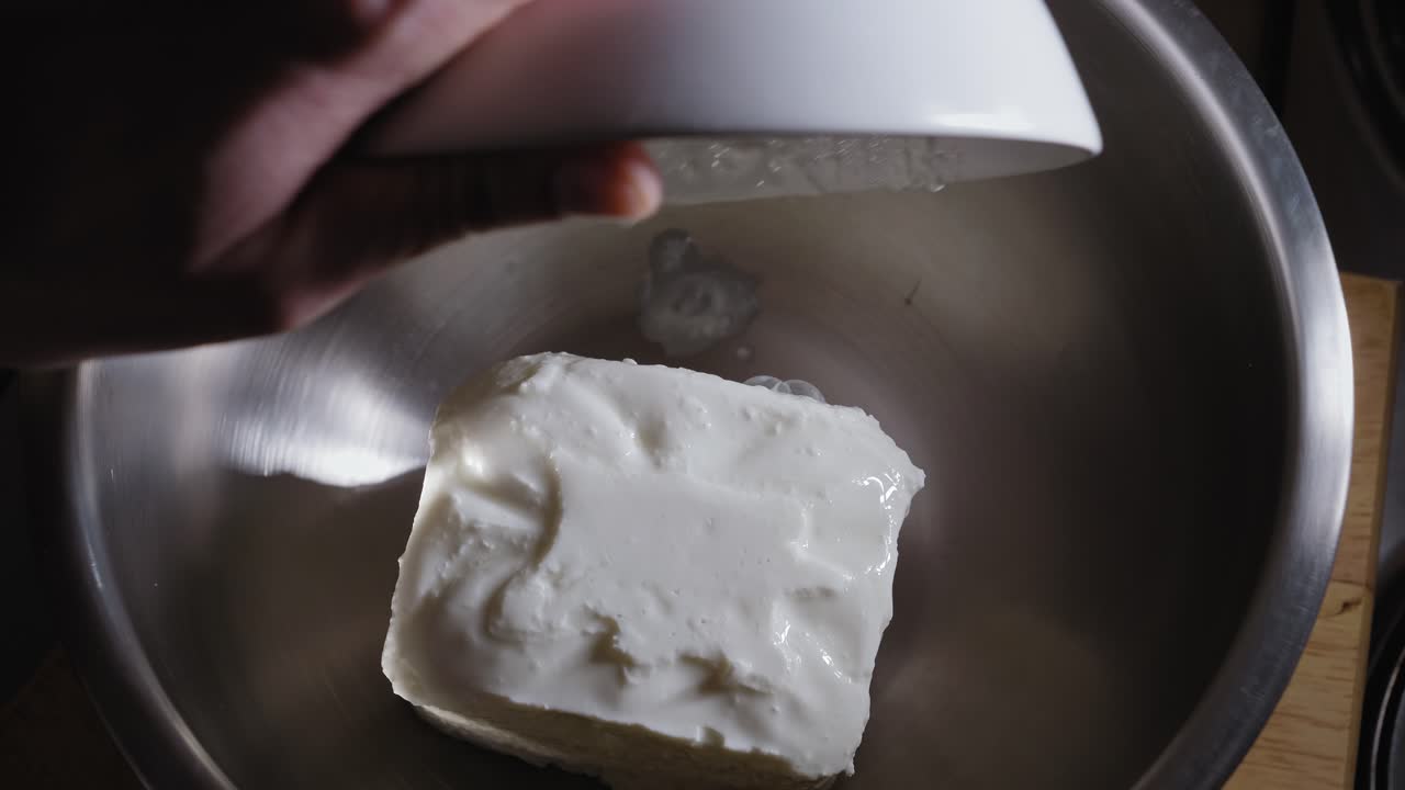 Tilberedning av osteterte, tilsetter ferskost, egg og melk i en metallbolle - Stabilt opptak