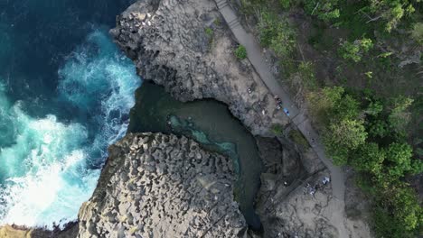 dramatic rising aerial rotates to show angel's billabong on bali shore