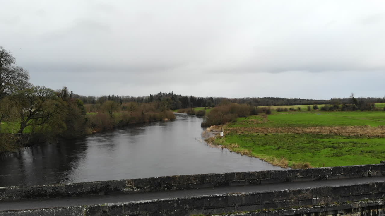 Aerial - Over the river with bridge road for car passing through