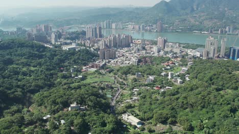 zhuwei district in taipei with urban skyline and greenery, river in background, aerial