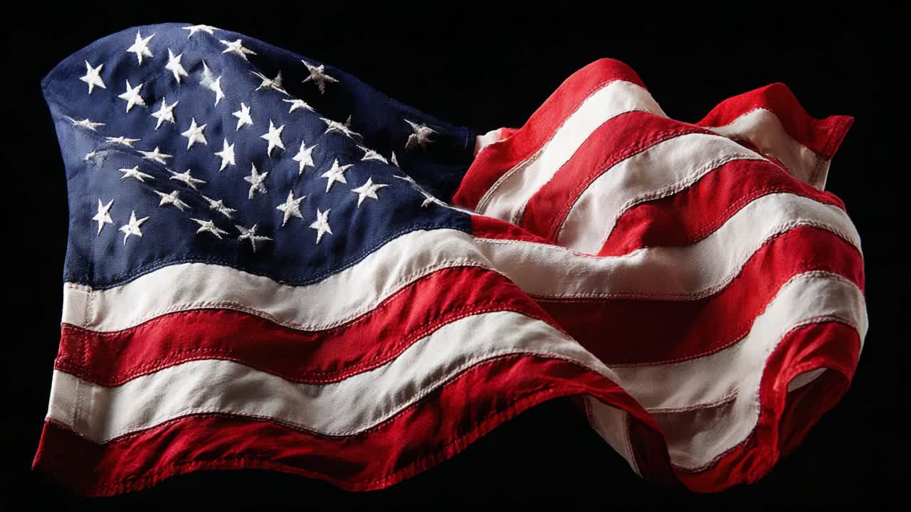 USAs flagg vaier grasiøst mot en mørk bakgrunn, som symboliserer frihet, enhet og nasjonal stolthet i sine dristige røde, hvite og blå farger.