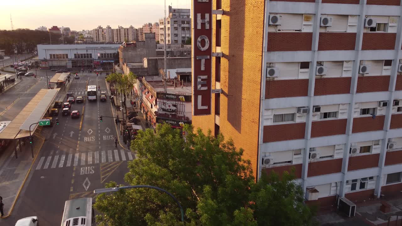 toma aérea del antiguo hotel vintage en buenos aires al lado de la estación de autobuses y el tráfico en la carretera durante la puesta de sol en buenos aires