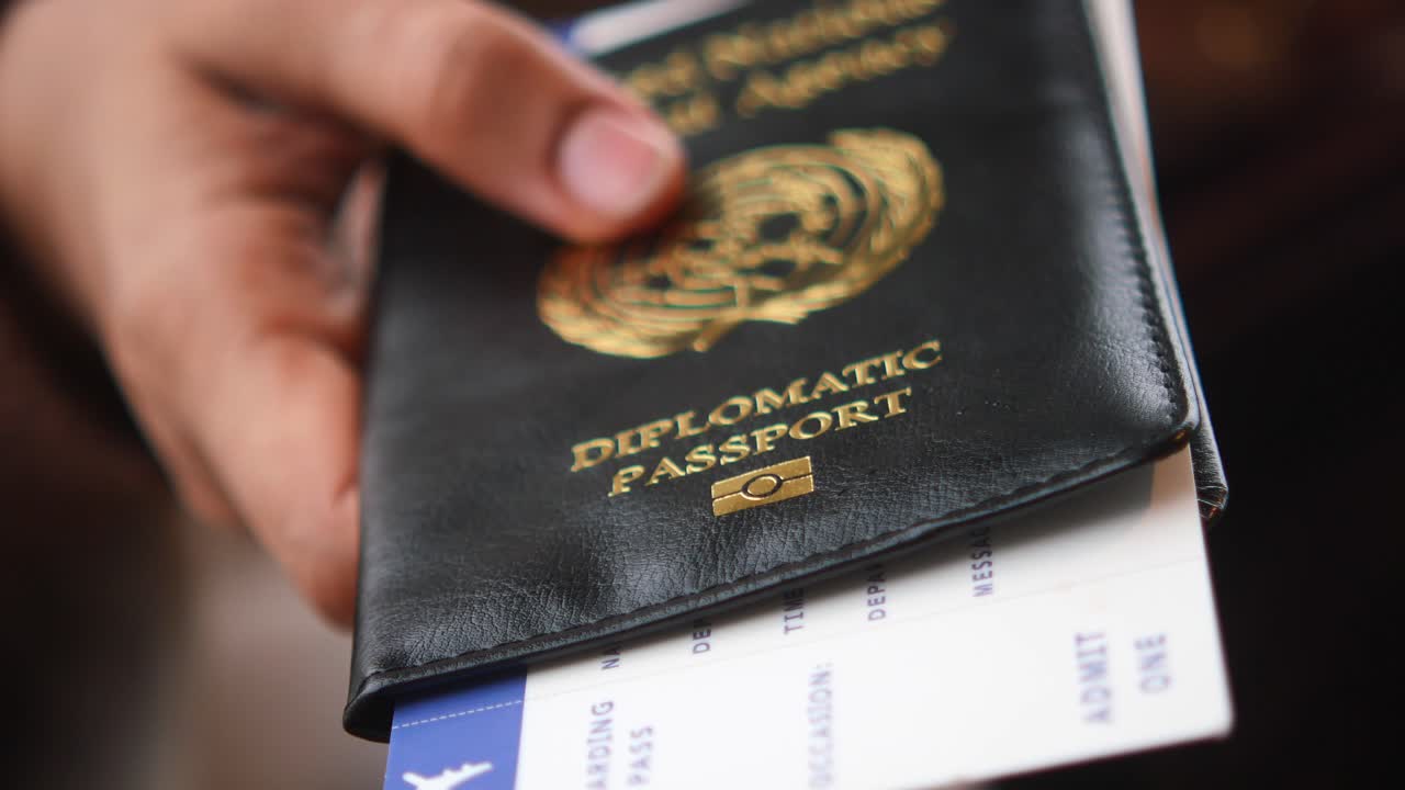 Ruka držící diplomatický pas s palubní vstupenkou
