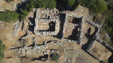 Ascending-top-shot-of-an-archeological-excavation-site-with-the-ancient-ruins-that-used-to-be-the-palace-of-Odysseus,-famous-from-the-mythology-written-by-Homer