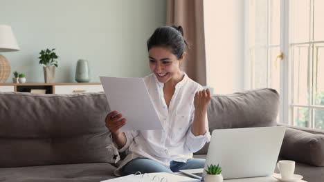 una mujer india muy feliz leyó buenas noticias fantásticas en una carta de papel.