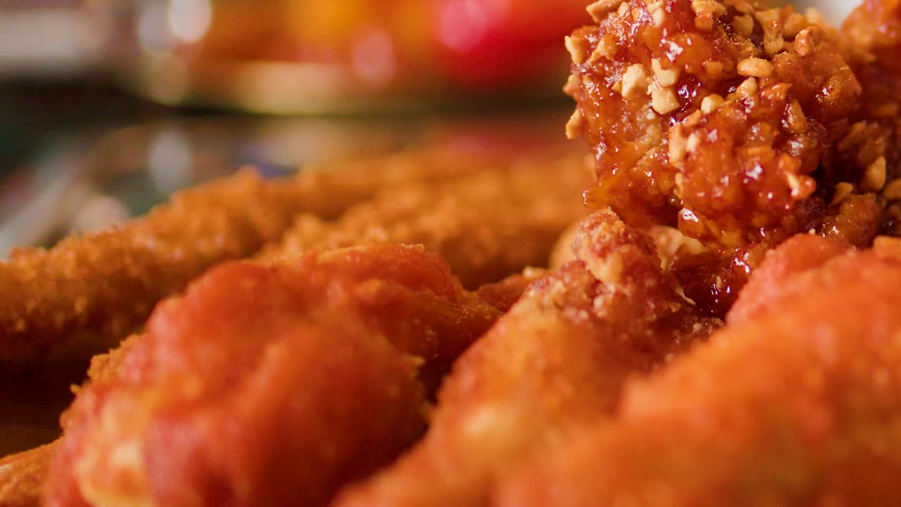 Macro di pezzi di pollo fritto dorato ricoperti di salsa piccante con messa a fuoco selettiva