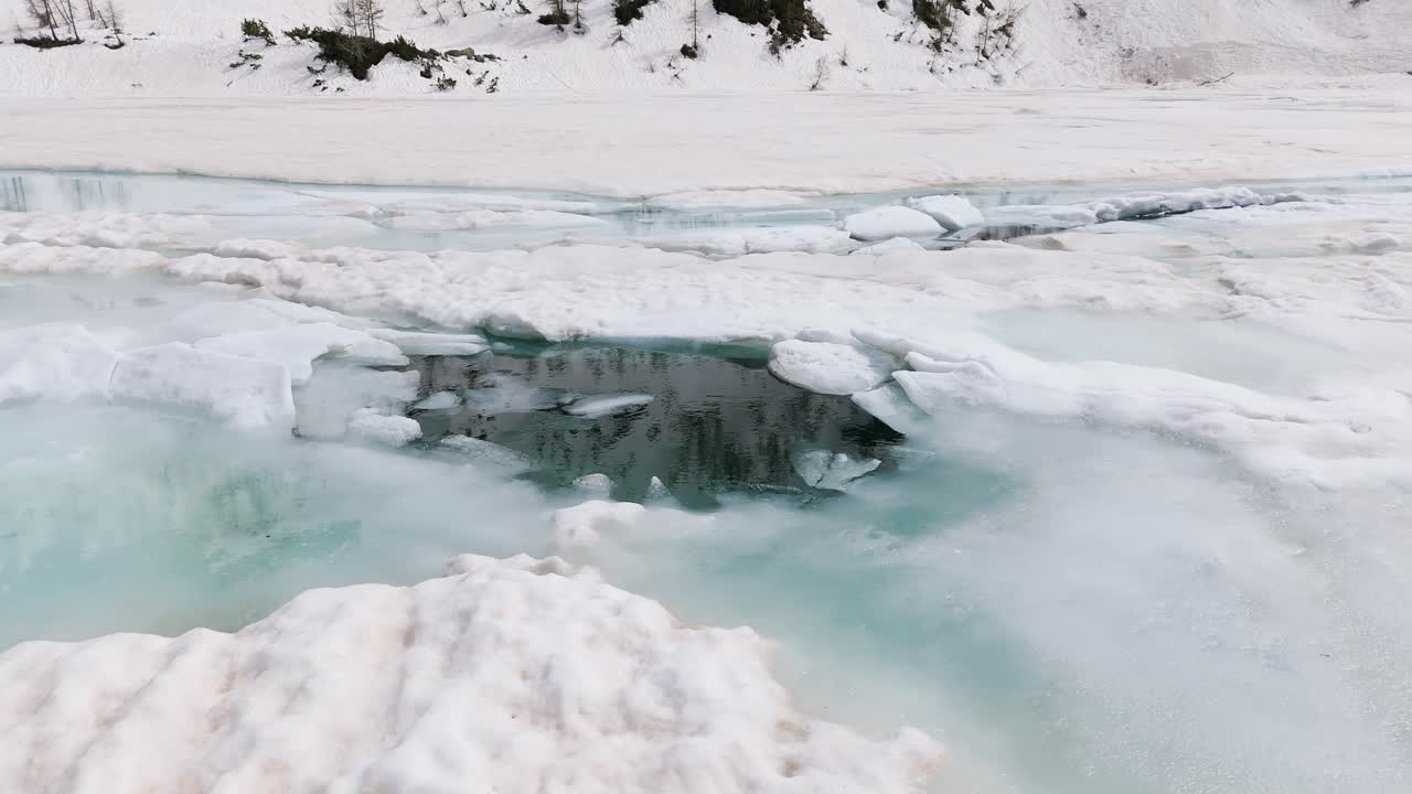 paisaje invernal sereno capturando charcos de agua en medio de nieve y hielo en los alpes de valmalenco, lombardía, italia