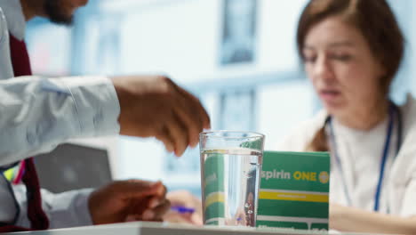 specialist giving an effervescent vitamin to patient in medical office