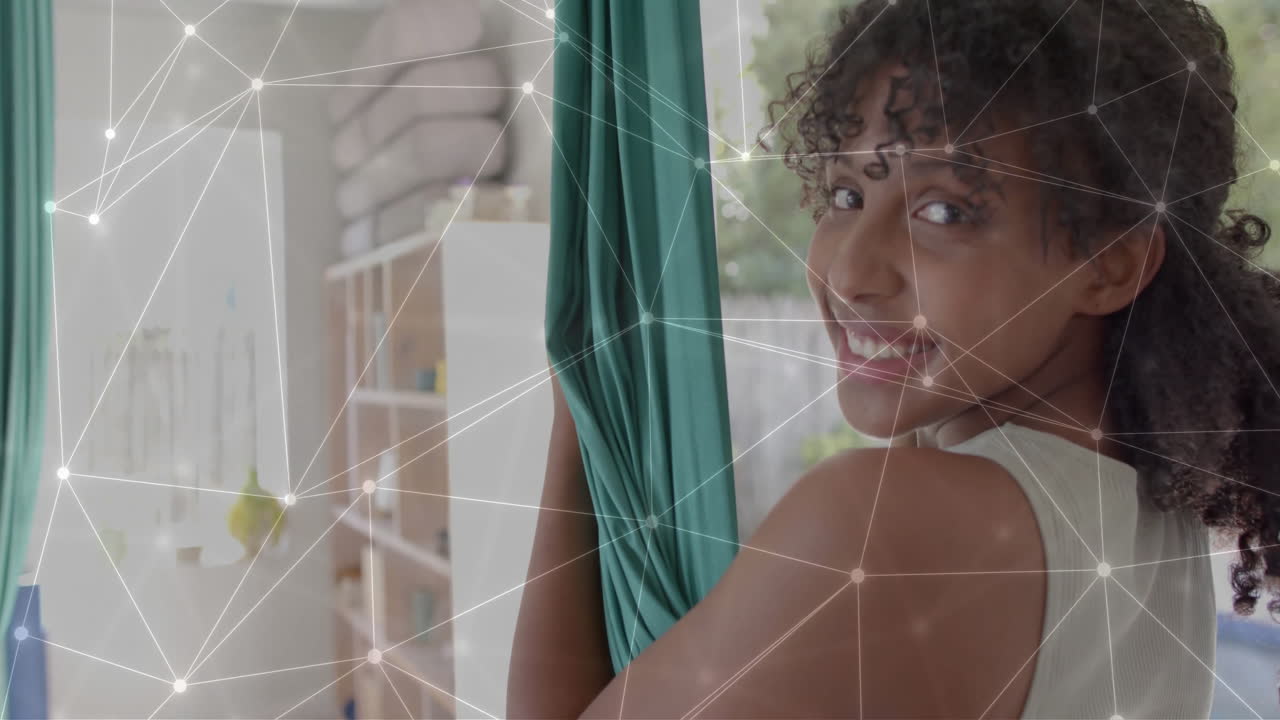 animación de red brillante sobre una adolescente biracial feliz practicando yoga aéreo