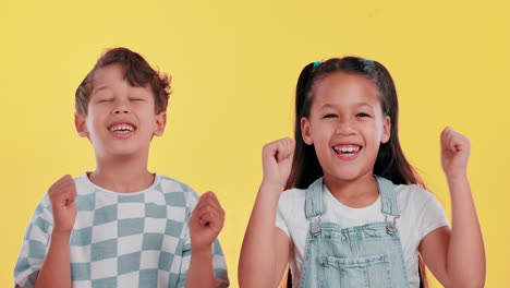 two happy kids celebrating success against a yellow background