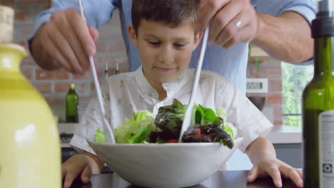 Father-and-son-preparing-fruit-salad-on-a-table-in-kitchen-at-home-4k