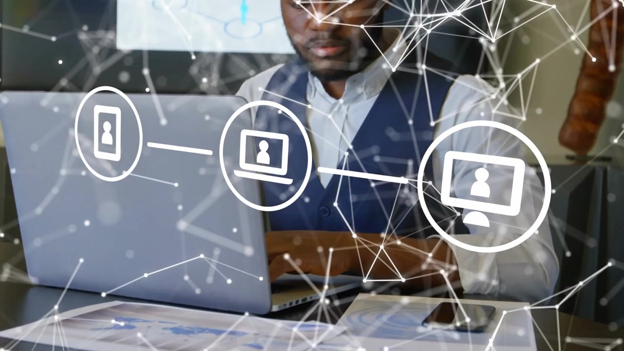 A stock photo of a young black businessman working on a laptop in a modern office