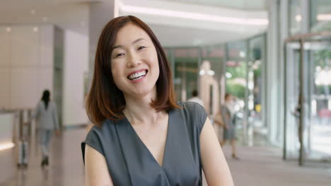 portrait of japanese business woman at work in busy office lobby