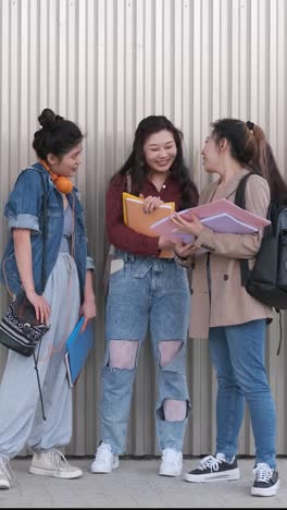 portrait of a group of female college students talking together outdoors on the street.