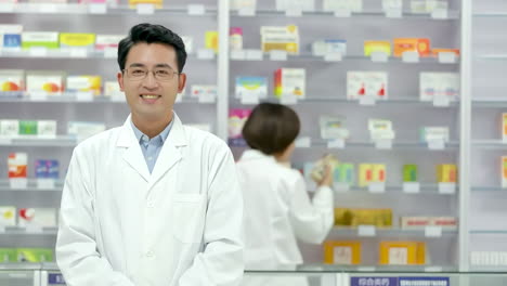 cheerful pharmacist man in a pharmacy, drugstore with shelves health care products