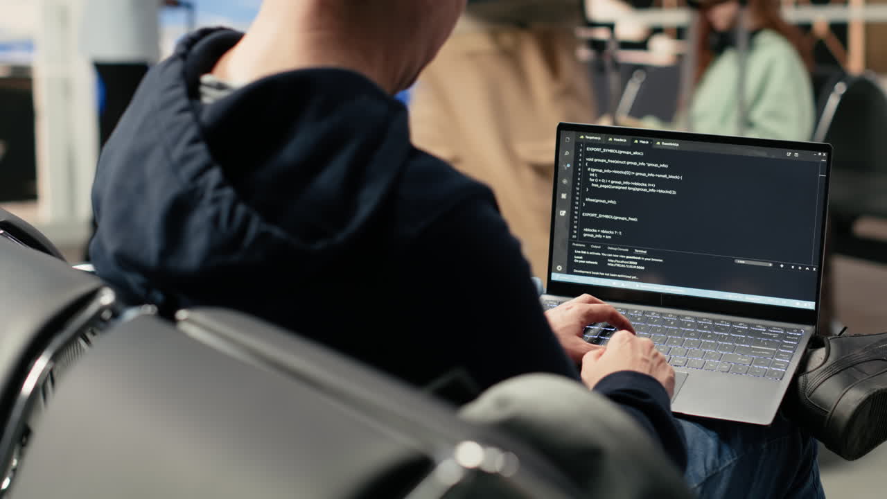 Programmer Working on Laptop at Airport Terminal