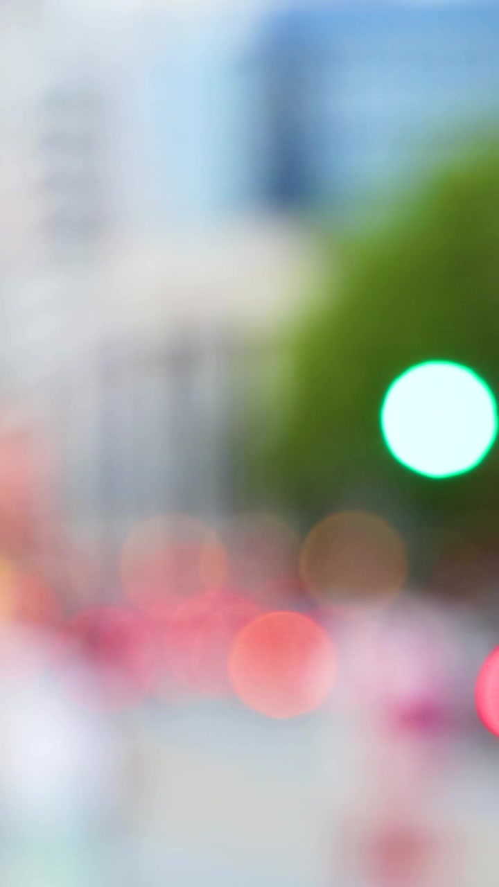Scena urbana sfocata con luci bokeh vibranti, pedoni in movimento e moderni edifici del centro città